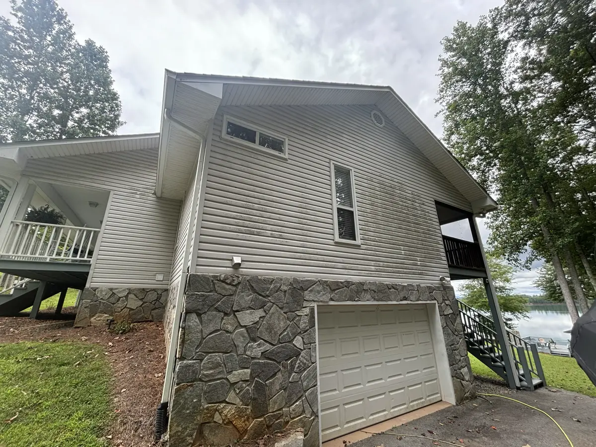House siding with visible dirt and algae before cleaning